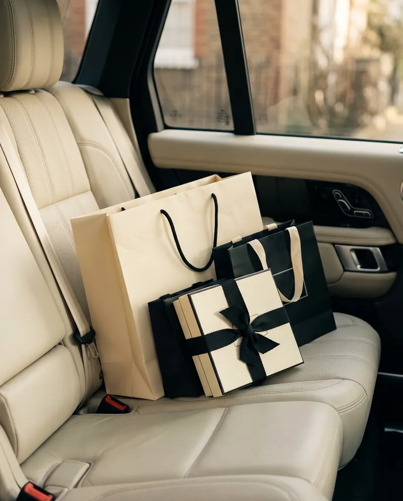 Bir Range Rover'ın arka koltuğunda alışveriş poşetleri